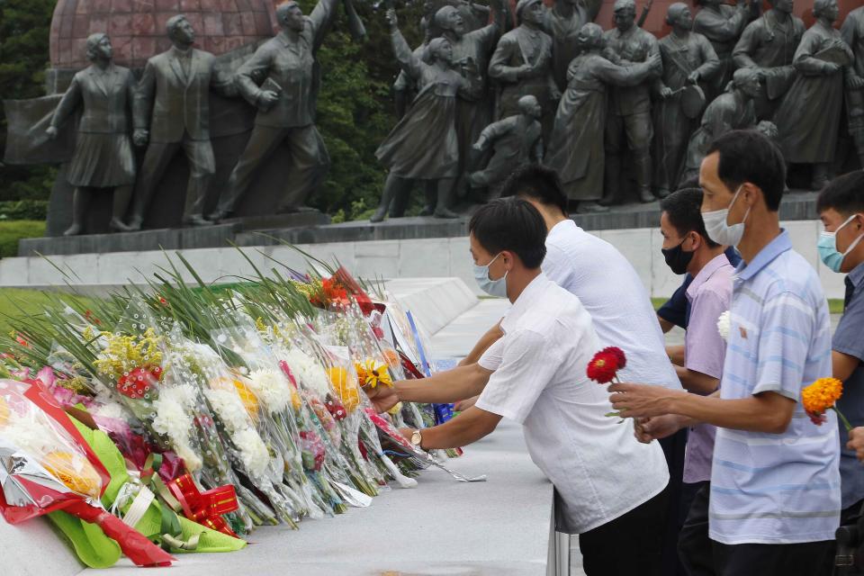 People lay flowers the statues of former North Korean leaders Kim Il Sung and Kim Jong Il on the occasion of the 67th anniversary of the end of the Korean War, which the country celebrates as the day of "victory in the fatherland liberation war" in Pyongyang, Monday, July 27, 2020. (AP Photo/Jon Chol Jin)