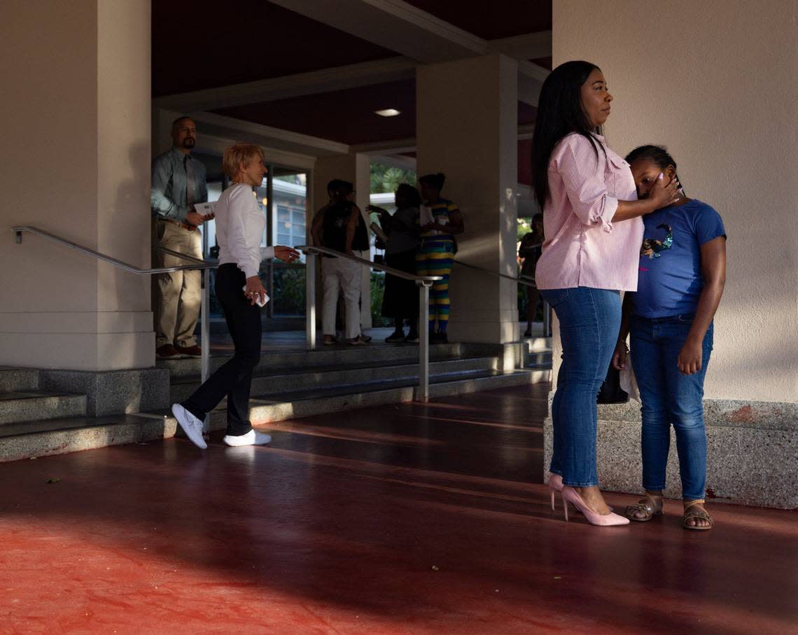 Aaleah Downs, right, holds her daughter, Olivia, while arriving at PACT’s assembly addressing the escalation of unaffordable rents and other issues with local government officials at Barry University in Miami Shores.