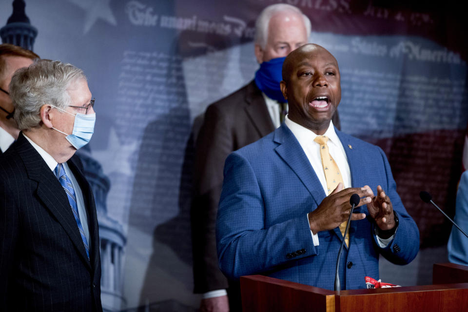 FILE - Sen. Tim Scott, R-S.C., right, accompanied by Senate Majority Leader Mitch McConnell of Ky., left, Sen. John Cornyn, R-Texas, center, and others, speaks at a news conference to announce a Republican police reform bill on Capitol Hill, June 17, 2020, in Washington. Scott has filed paperwork to enter the 2024 Republican presidential race. He'll be testing whether a more optimistic vision of America’s future can resonate with GOP voters who have elevated partisan brawlers in recent years. (AP Photo/Andrew Harnik, File)