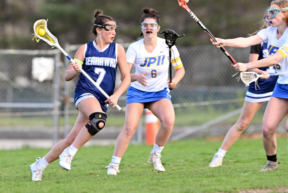 Ella Bartolomei of Cape Cod Academy moves on Delaney Burrell (6) and Maggie Crofford of St. John Paul II on Monday, April 24, 2023.