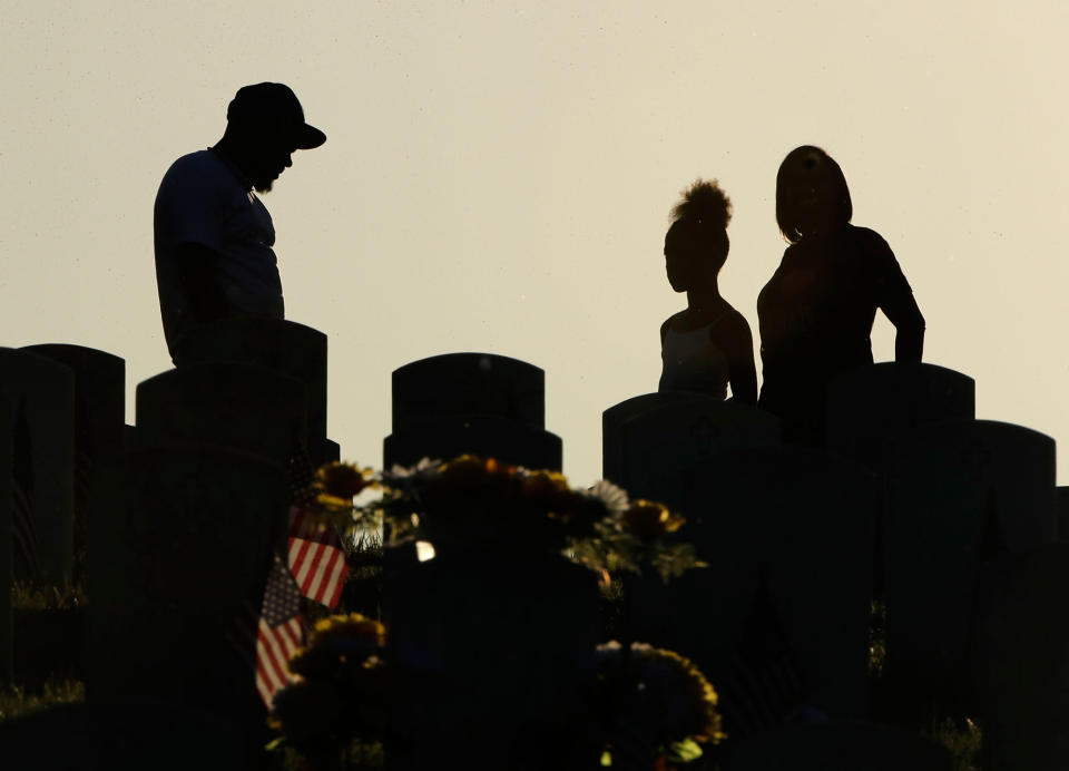 <p>Visitors pause at a grave at Leavenworth National Cemetery on May 28, 2017, in Leavenworth, Kan. (Photo: Charlie Riedel/AP) </p>