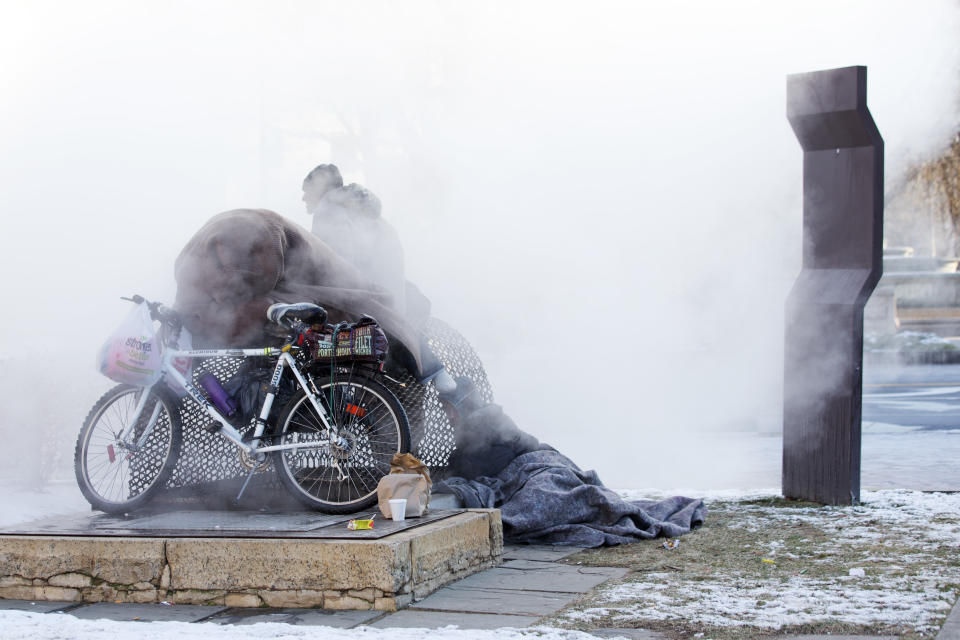 Nicholas Simmons, 20, of Greece, N.Y., right, warms himself on a steam grate with three homeless men by the Federal Trade Commission, just blocks from the Capitol, during frigid temperatures in Washington, Saturday, Jan. 4, 2014. On New Year’s Day, Simmons disappeared from his parents’ house in a small upstate New York town, leaving behind his wallet, cellphone and everything else. Four days later, an Associated Press photographer, looking for a way to illustrate unusually cold weather, took his picture as he warmed himself on a steam grate a few blocks from the U.S. Capitol. His parents Paul and Michelle Simmons saw the photograph in USA Today Sunday morning after it was brought to their attention through a Facebook page set up to help find their son, according to police and family friends, and were able to report his location to D.C. police who transported him to a hospital where he was reunited with his father and brother who drove all day to find him. (AP Photo/Jacquelyn Martin)