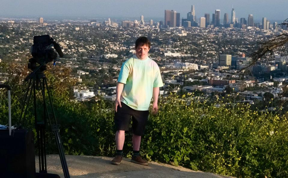 tommy jessop standing next to the los angeles skyline