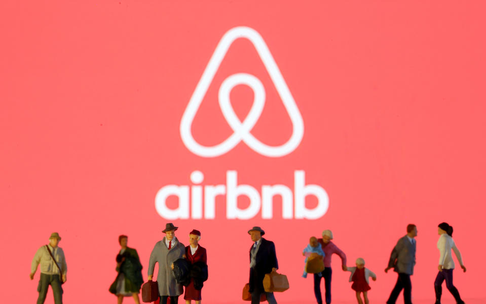 Small toy figures are seen in front of diplayed Airbnb logo in this illustration taken March 19, 2020. REUTERS/Dado Ruvic/Illustration