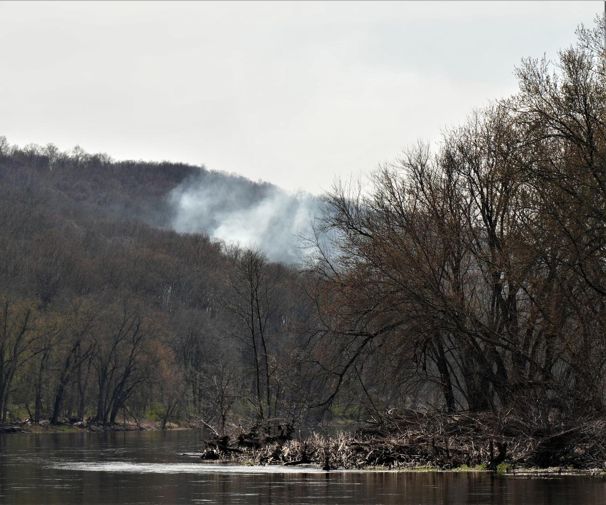 Smoke rises from a wildfire as seen from the Pennsylvania side of the Delaware River just upstream from the head of Shawnee Island. The fire was confined to a five-acre area within Worthington State Forest and was brought under control by crews from the New Jersey Forest Fire Service and the National Park Service.