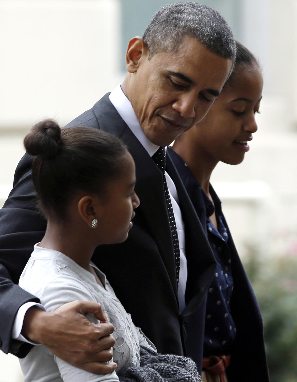 President Barack Obama walks with his daughters Sasha, foreground, and Malia as they leave St. John's Episcopal Church and return to the White House in Washington, on Sunday, Oct. 28, 2012. (AP Photo/Jacquelyn Martin)