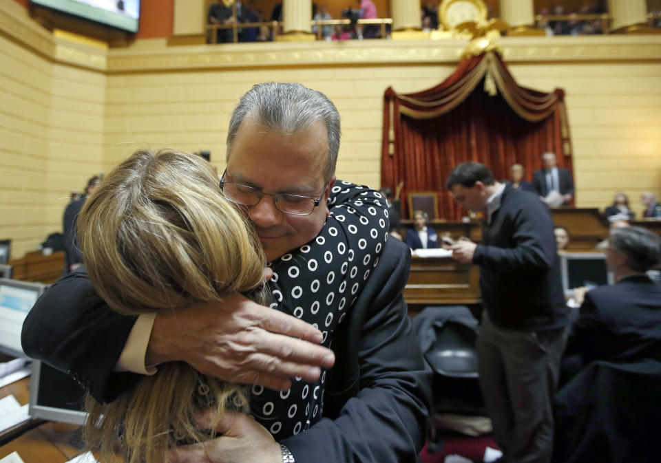 Democrat Nicholas Mattiello, of Cranston, R.I., is hugged by Rep. Doreen Costa after he was elected as the new House Speaker by the Rhode Island House of Representatives at the Statehouse in Providence, Tuesday, March 25, 2014. Mattiello was elected after the abrupt resignation of Gordon Fox, one of the most powerful figures in state government, after his home and Statehouse office were raided as part of a criminal probe. (AP Photo/Elise Amendola)