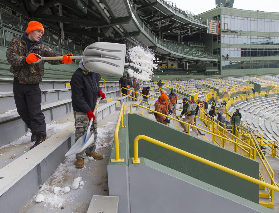 Workers clear ice and snow from the seats at Lambeau Field on Friday, Jan. 3, 2014, in Green Bay, Wis. in preparation for Sunday's NFL football wild-card playoff game between the Green Bay Packers and San Francisco 49ers.(AP Photo/Mike Roemer)
