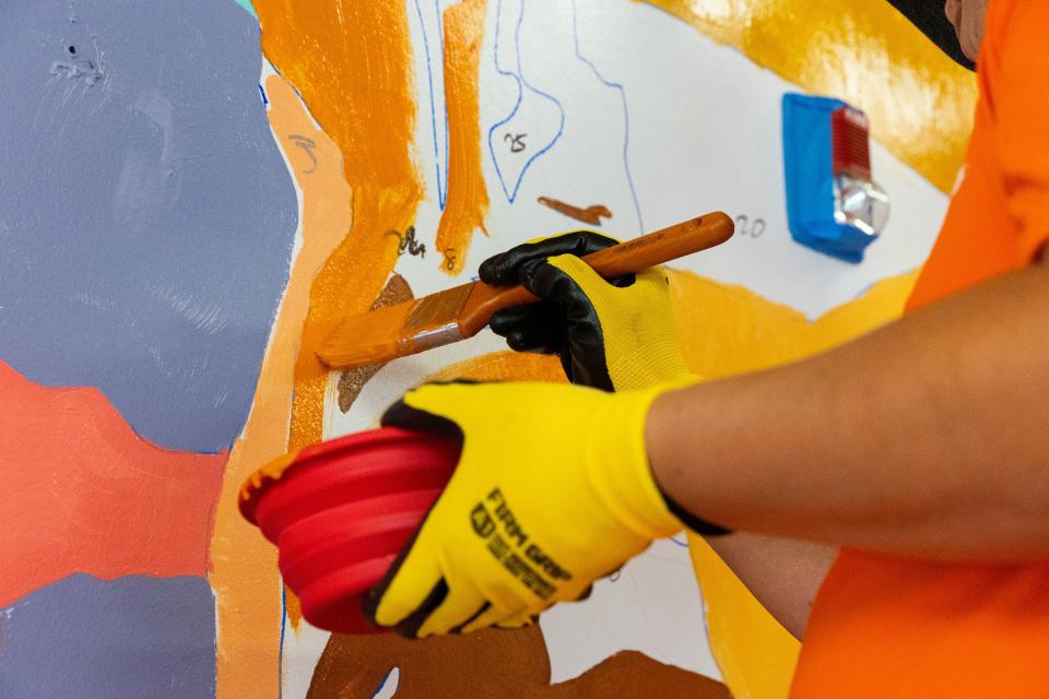 Xiangwei Zhang works on a paint-by-number mural in the community room at Freedom Landing in Salt Lake City on Wednesday, July 12, 2023. Mural artists Isaac Caruso and Leslie Minnis created mural outlines and volunteers helped fill them in with the correct paint colors. | Megan Nielsen, Deseret News