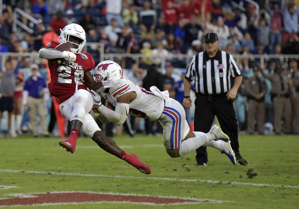 Florida Atlantic's James Charles, left, scores a touchdown against SMU's Tyeson Neals during the first half of the Boca Raton Bowl NCAA college football game Saturday, Dec. 21, 2019, in Boca Raton, Fla. (Michael Laughlin/South Florida Sun-Sentinel via AP)
