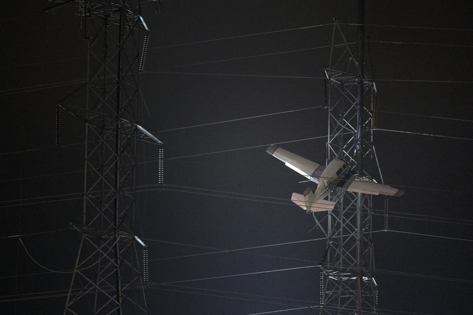 A small plane rests on live power lines after crashing, Sunday, Nov. 27, 2022, in Montgomery Village, a northern suburb of Gaithersburg, Md. (AP Photo/Tom Brenner)