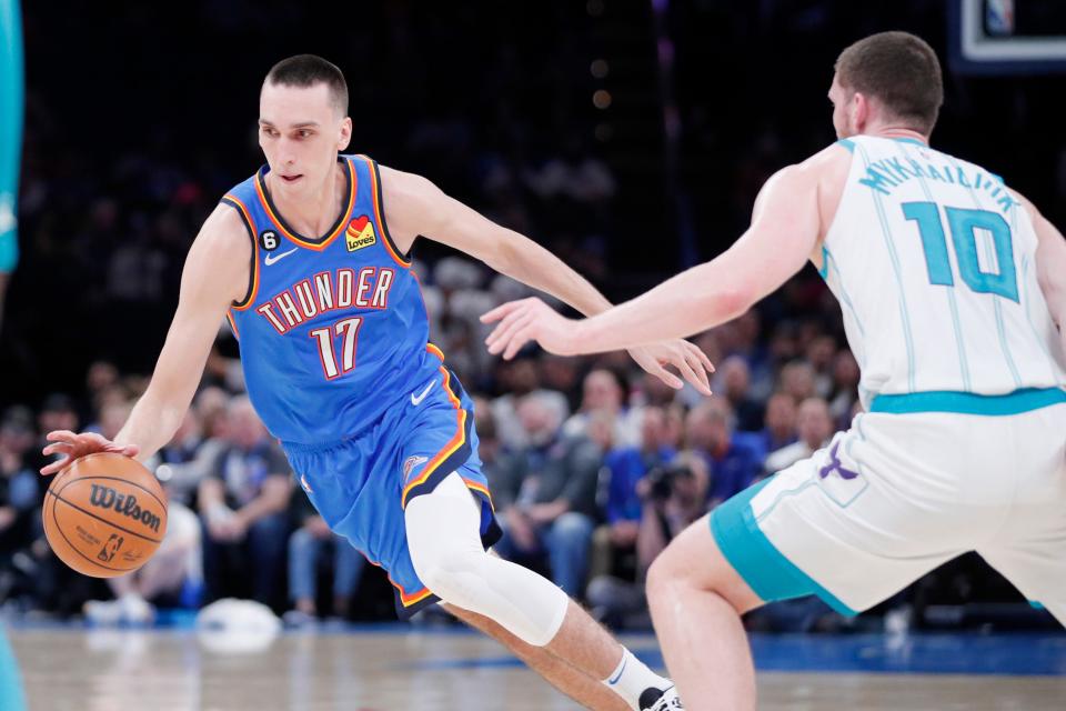 Oklahoma City Thunder forward Aleksej Pokusevski (17) goes past Charlotte Hornets guard Svi Mykhailiuk (10) during an NBA basketball game between the Oklahoma City Thunder and the Charlotte Hornets at Paycom Center in Oklahoma City, Tuesday, March 28, 2023.