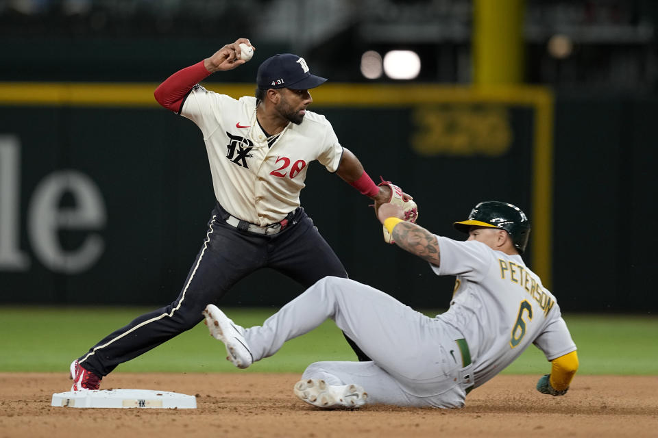 Texas Rangers shortstop Ezequiel Duran throws to first after forcing Oakland Athletics' Jace Peterson (6) at second during the fourth inning of a baseball game Friday, April 21, 2023, in Arlington, Texas. Athletics' Aledmys Diaz was safe at first. (AP Photo/Tony Gutierrez)