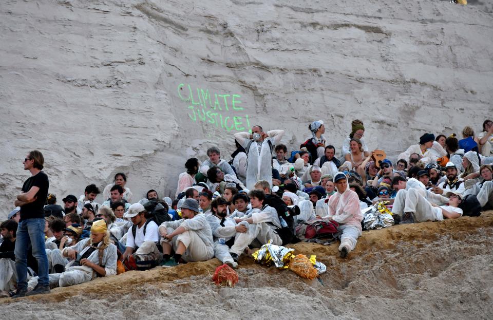 Climate activists sit on the ground after entering the Garzweiler brown coal mine in Garzweiler, western Germany, on June 22, 2019, during a weekend of massive protests in a growing "climate civil disobedience" movement. - Anti-coal activists try to occupy the Garzweiler open-cast lignite mine in a protest to demand action against global warming, now one of the hottest issues on the European political agenda. (Photo by INA FASSBENDER / AFP)        (Photo credit should read INA FASSBENDER/AFP/Getty Images)