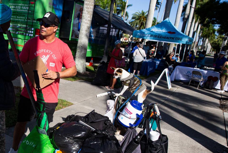 Xavier Luciano, a social work student at FGCU surveys a women experiencing homelessness at the SWFL Hunger and Homeless CoalitionÕs annual "point in time" homeless count at City of Palms Park in Fort Myers on Saturday, Jan. 27, 2024. Vendors were set up at the event to help the homeless which included, food, hygiene kits, clothes and other help.