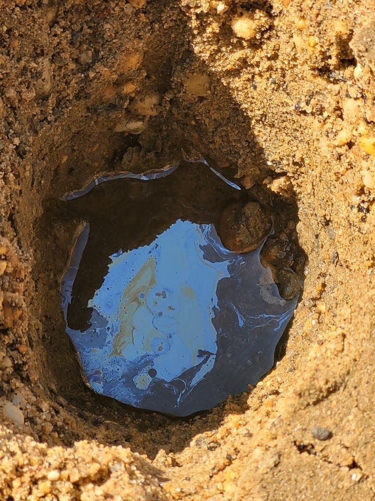 A one-foot hole that backfilled with water and an apparent sheen near the Brant Point construction in Atlantic Highlands.