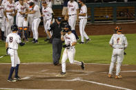 Virginia Logan Michaels (12) scores on a Chris Newell homer in the fifth inning during a baseball game in the College World Series Thursday, June 24, 2021, at TD Ameritrade Park in Omaha, Neb. (AP Photo/John Peterson)