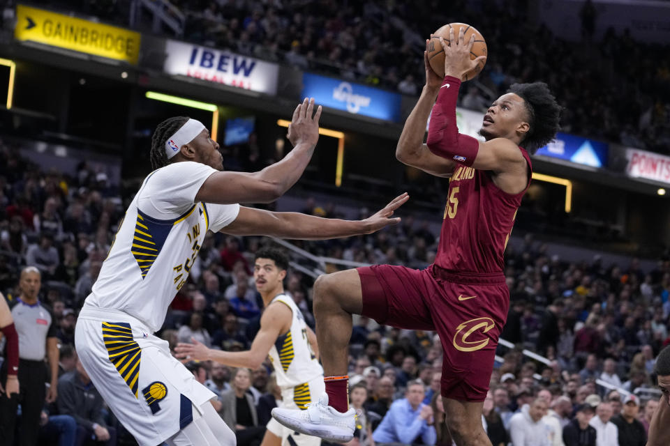 Cleveland Cavaliers forward Isaac Okoro (35) shoots over Indiana Pacers center Myles Turner (33) during the first half of an NBA basketball game in Indianapolis, Monday, March 18, 2024. (AP Photo/Michael Conroy)