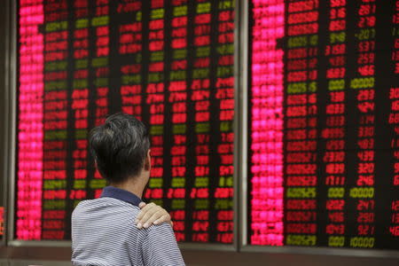 An investor looks at an electronic board showing stock information at a brokerage house in Beijing, August 27, 2015. REUTERS/Jason Lee