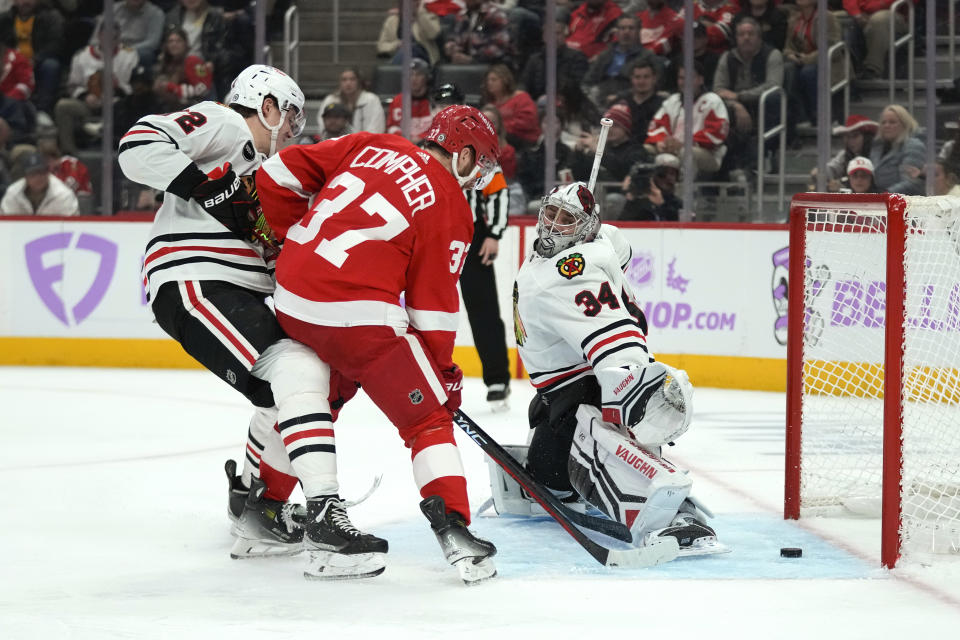 Detroit Red Wings left wing J.T. Compher (37) scores on Chicago Blackhawks goaltender Petr Mrazek (34) as Alex Vlasic (72) defends in the second period of an NHL hockey game Thursday, Nov. 30, 2023, in Detroit. (AP Photo/Paul Sancya)