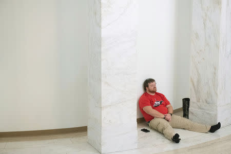 A striking teacher rests In the hallway inside the Capitol building where lawmakers rejected a bill that would have opened the first charter schools in the state, in Charleston, West Virginia, U.S., February 19, 2019. REUTERS/Lexi Browning