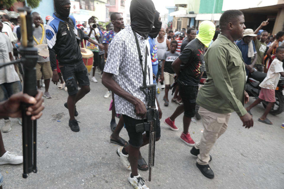 Members of "G9 and Family" protect the leader Jimmy Chérizier, right, better known as Barbecue, during a protest against Haitian Prime Minister in Port-au-Prince, Haiti, Tuesday, Sept. 19, 2023. (AP Photo/Odelyn Joseph)