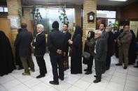 Iranians wait in line to vote at a polling station during parliamentary elections in Tehran,