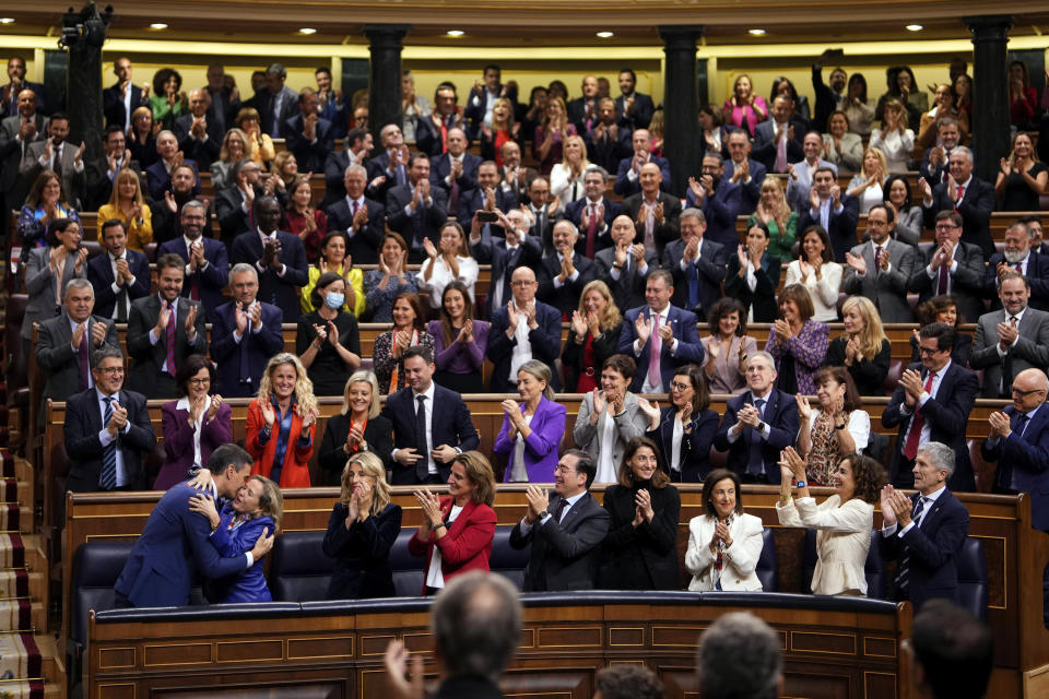 Spain's acting Prime Minister Pedro Sanchez, bottom left, embraces Spain's acting Deputy Prime Minister and Economy Minister Nadia Calvino after he was chosen by a majority of legislators to form a new government after a parliamentary vote at the Spanish Parliament in Madrid, Spain, Thursday, Nov. 16, 2023. (AP Photo/Manu Fernandez)