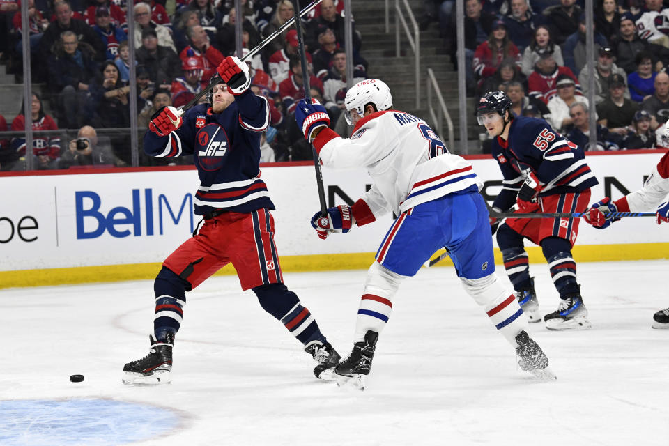 Montreal Canadiens' Mike Matheson (8) checks Winnipeg Jets' Nikolaj Ehlers (27) as a pass comes over to Ehlers during the second period of NHL hockey game action in Winnipeg, Manitoba, Monday, Dec. 18, 2023. (Fred Greenslade/The Canadian Press via AP)