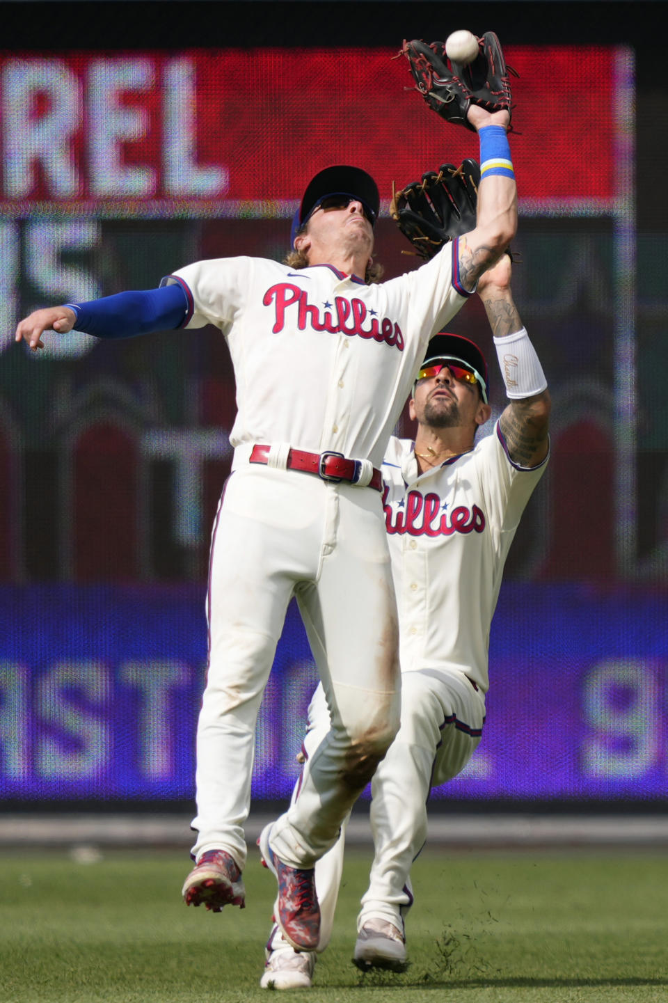 Philadelphia Phillies second baseman Bryson Stott, left, and right fielder Nick Castellanos collide as Stott catches a fly out by San Diego Padres' Manny Machado during the ninth inning of the first baseball game in a doubleheader, Saturday, July 15, 2023, in Philadelphia. (AP Photo/Matt Slocum)