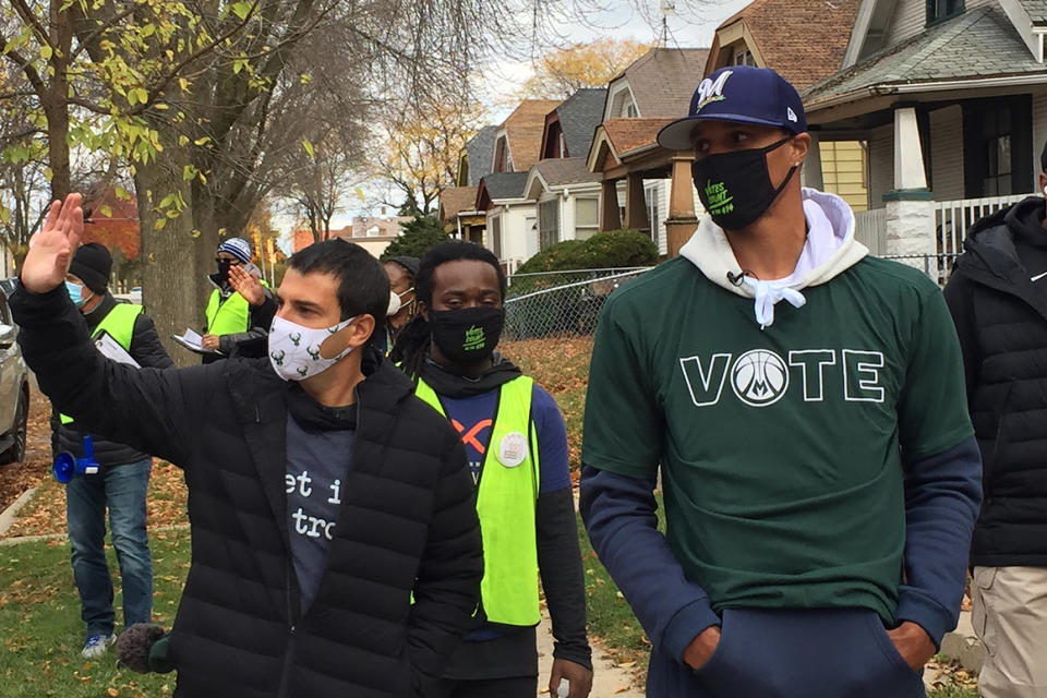 FILE - In this Oct. 24, 2020 file photo, Milwaukee Bucks senior vice president Alex Lasry, left, and then-Bucks guard George Hill walk through a Milwaukee neighborhood during a voter canvassing effort. Democrat Alex Lasry, a Bucks executive and son of a billionaire, announced Wednesday, Feb. 17, 2021, that he's running for the U.S. Senate in 2022 for the seat currently held by Republican Ron Johnson. (AP Photo/Steve Megargee File)