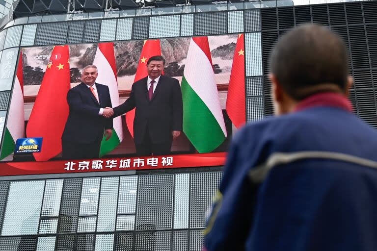 Una pantalla muestra el saludo entre el presidente chino, Xi Jinping, y el premier húngaro Victor Orban, durante una gira de Orban en Pekín