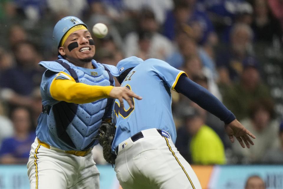 Milwaukee Brewers catcher William Contreras nearly colides with Carlos Rodriguez as he makes a late throw on a ball hit by Toronto Blue Jays' Isiah Kiner-Falefa during the fourth inning of a baseball game Tuesday, June 11, 2024, in Milwaukee. (AP Photo/Morry Gash)