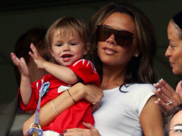 <p>Neal Simpson/EMPICS/Getty</p> Victoria Beckham holding her son Romeo James Beckham while watching David Beckham play.