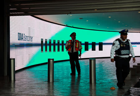 Police officer and a security guard stand guard after people were evacuated from the Mexican headquarters of Spain's BBVA due to what the bank said were two anonymous emails threatening violent acts against its corporate offices, in Mexico City, Mexico March 13, 2019. REUTERS/Henry Romero