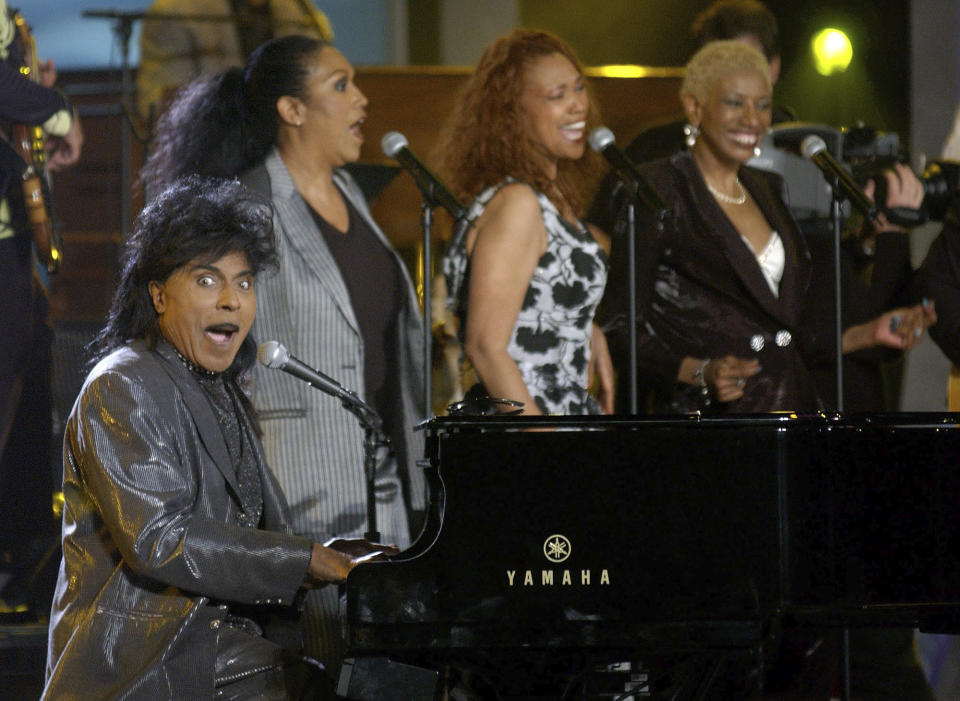 FILE - In this April 21, 2002 file photo, Little Richard performs "Good Golly Miss Molly" with the Pointer Sisters providing backup vocals during the "supergroup" finale of "American Bandstand's 50th...A Celebration," at the Pasadena Civic Auditorium in Pasadena, Calif. Little Richard, the self-proclaimed “architect of rock ‘n’ roll” whose piercing wail, pounding piano and towering pompadour irrevocably altered popular music while introducing black R&B to white America, has died Saturday, May 9, 2020. (AP Photo/Chris Pizzello, File)