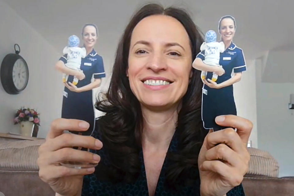 In this image taken from an online video interview with The Associated Press, Claudia Anghel, a Romanian midwife working in England, poses with two cardboard representations of herself, received from a patient as a thank you present, in Nuneaton, England, Tuesday, July, 28, 2020. Anghel's success story as one of 600,000 Romanians in Britain is at the same time a telling sign of how the deficiencies of her home country's health care system and the bleak prospects for a better future for herself and her family have left huge gaps in Romanian society and its health care system. (AP Photo)