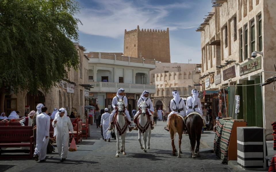 Horse-mounted police officers patrol the streets of Doha - Getty