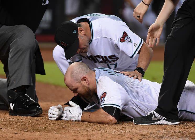 Chris Iannetta is tended to by Diamondbacks manager Torey Lovullo after getting hit in the face by a pitch on Friday night. (Getty Images)