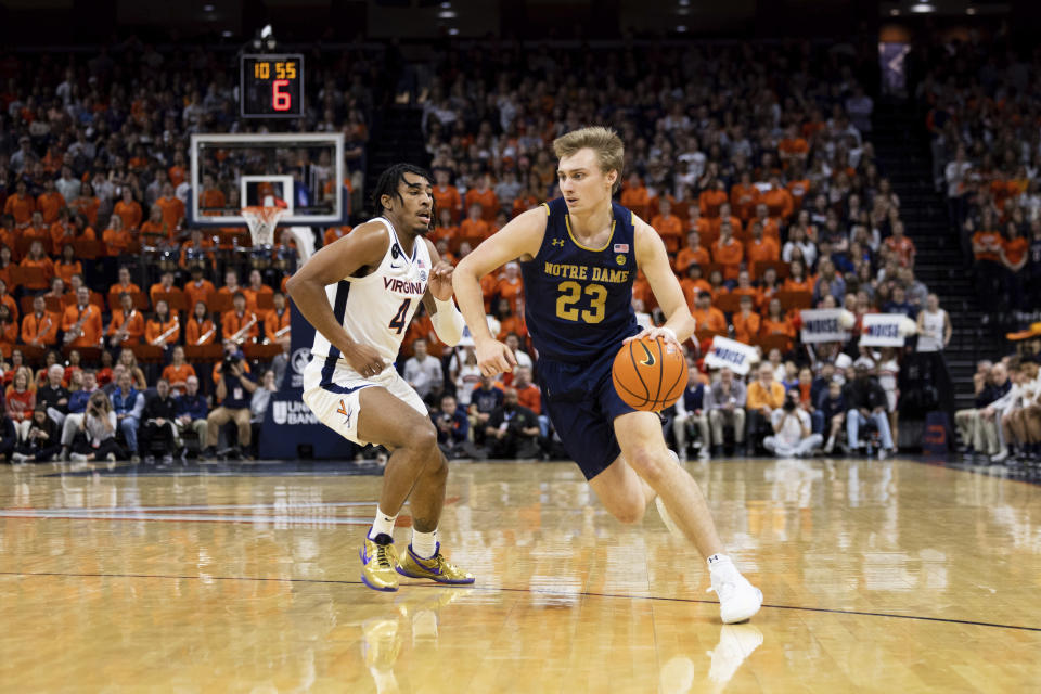 Notre Dame's Dane Goodwin (23) dribbles the ball past Virginia's Armaan Franklin (4) during the first half of an NCAA college basketball game in Charlottesville, Va., Saturday, Feb. 18, 2023. (AP Photo/Mike Kropf)
