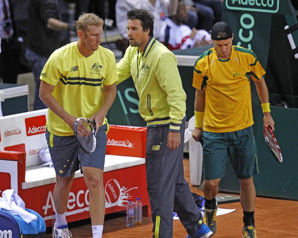 Australian team captain Patrick Rafter, center, encourages his players Lleyton Hewitt, right, and Chris Guccione during their doubles match against French pair Jo-Wilfried Tsonga and Richard Gasquet, in the first round of the Davis Cup between France and Australia, in La Roche sur Yon, western France, Saturday Feb. 1, 2014. (AP Photo/Remy de la Mauviniere)