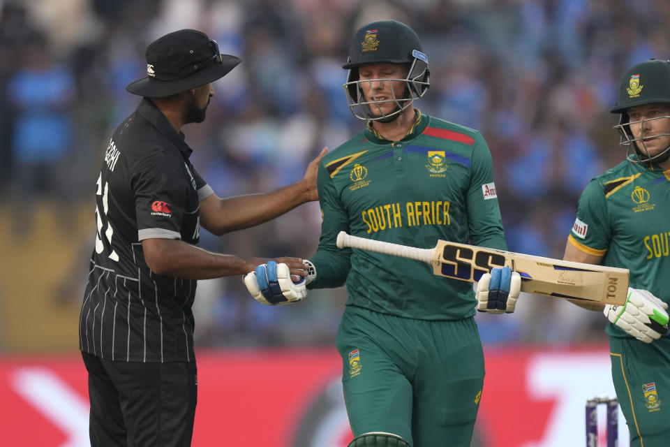 South Africa's Rassi Van Der Dussen, right, leaves the ground after losing his wicket is greeted by New Zealand's Ish Sodhi during the ICC Men's Cricket World Cup match between New Zealand and South Africa in Pune, India, Wednesday, Nov.1, 2023. (AP Photo/Manish Swarup)