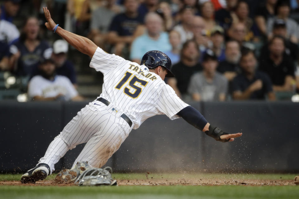 Milwaukee Brewers' Tyrone Taylor gestures after sliding safely into home to score during the fourth inning of a baseball game against the Chicago White Sox, Saturday, July 24, 2021, in Milwaukee. (AP Photo/Aaron Gash)