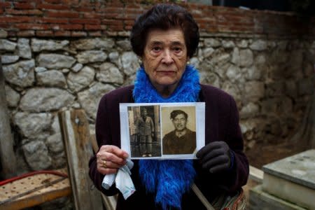 Carmen Benito Alcantarilla holds pictures of her uncle Valentin Alcantarilla Mercado who was shot in 1940 by forces of dictator Francisco Franco in Guadalajara's cemetery, Spain, January 28, 2016. Picture taken January 28, 2016. REUTERS/Juan Medina