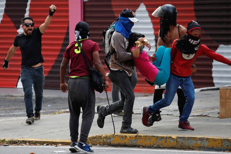 Demonstrators carry a girl during a protest of opposition supporters against Venezuelan President Nicolas Maduro's government in Caracas, Venezuela January 23, 2019. REUTERS/Carlos Garcia Rawlins