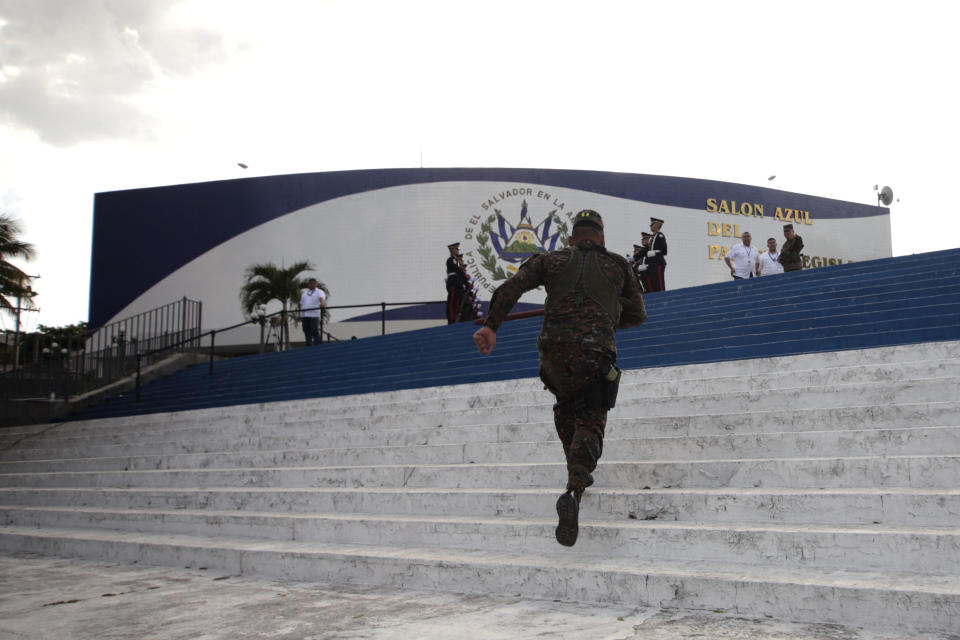 An Armed Special Forces soldier runs up a flight of steps congressional steps to enter the lawmakers' chambers, following orders of President Nayib Bukele, who had been locked in battle with the opposition-controlled congress, in San Salvador, El Salvador, Sunday, Feb. 9, 2020 . Bukele wanted lawmakers to approve funding for a security plan to control gangs, but they had refused to convene for a vote, saying they wanted more information. So he sent armed troops into congress to coerce a vote. (AP Photo/Salvador Melendez)