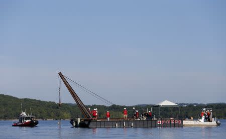 July 23, 2018; Branson, MO, USA; Using a barge mounted crane, a salvage crew from Fitzco Marine Group begin the process of raising a duck boat from below the surface of Table Rock Lake on Monday, July 23, 2018. 17 people were killed last week when the duck boat sank. Mandatory Credit: Nathan Papes/News-Leader via USA TODAY NETWORK