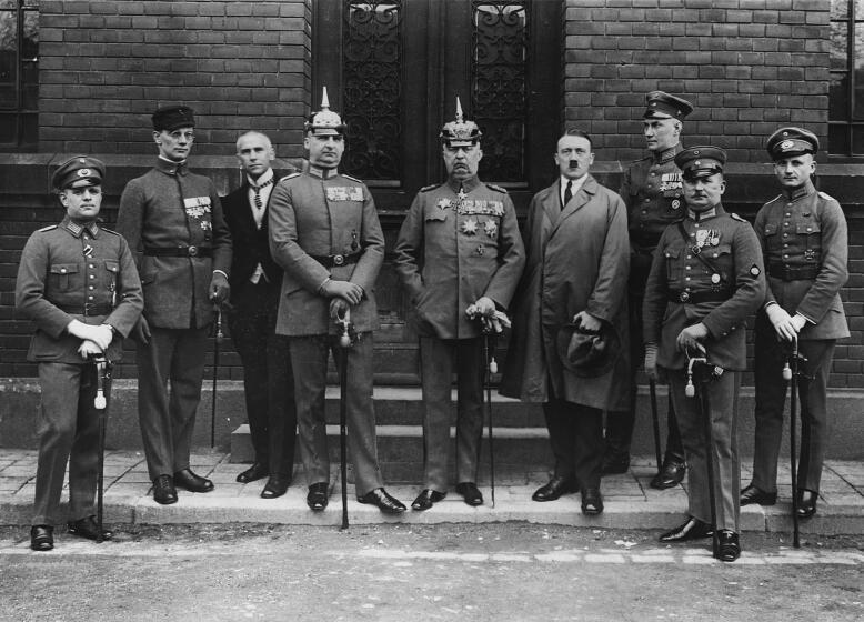 The principal collaborators of the failed Munich Beer Hall uprising pose after their trial. They are, from left to right, Pernet, Weber, Frick, Kriebel, General Ludendorff, Adolf Hitler, Bruckner, Rohm and Wagner. (Photo by © Hulton-Deutsch Collection/CORBIS/Corbis via Getty Images)