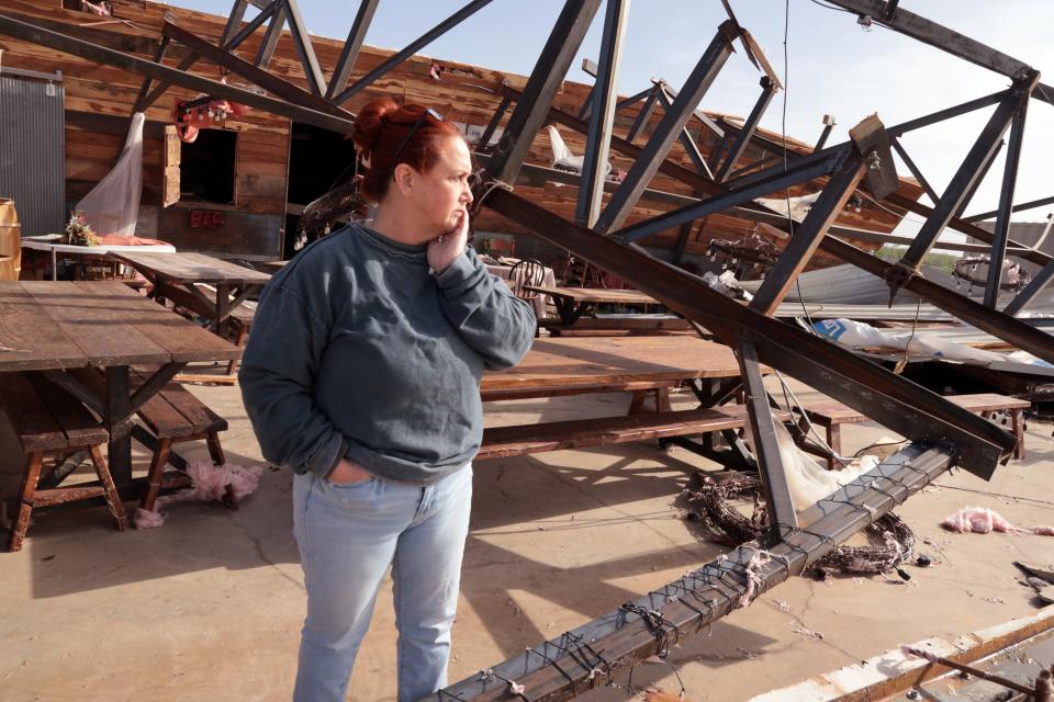 Kimber Hendrickson surveys damage from Wednesday's tornado on Thursday, April 20, 2023. Her Scissortail Silos wedding venue in Cole, Okla., received major damage.