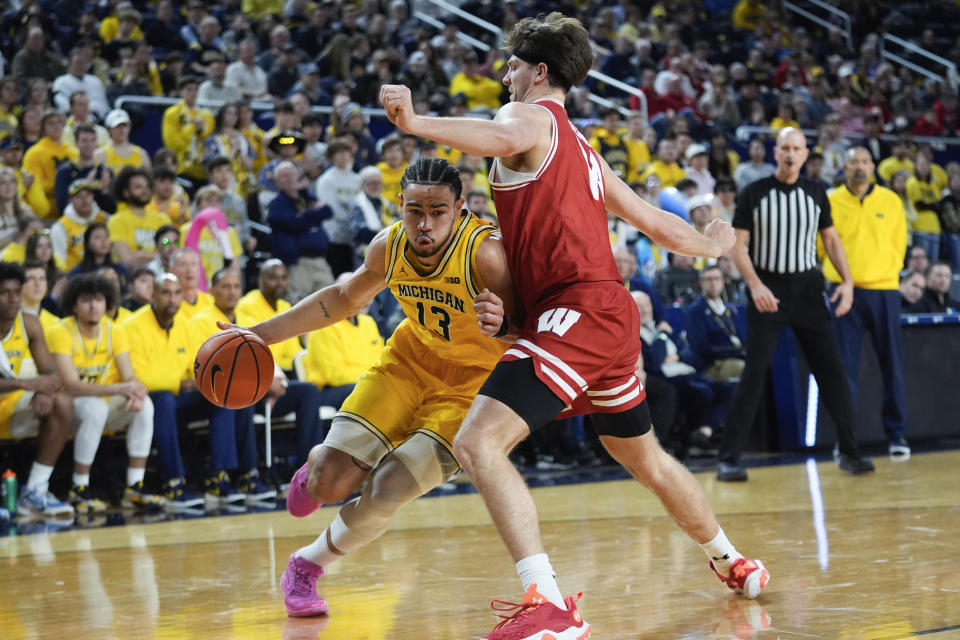 Michigan Wolverines forward Olivier Nkamhoua (13) drives on Wisconsin forward Carter Gilmore (14) in the second half of an NCAA college basketball game in Ann Arbor, Mich., Wednesday, Feb. 7, 2024. (AP Photo/Paul Sancya)